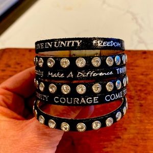 Humanity leather cuff with jewels and writing.